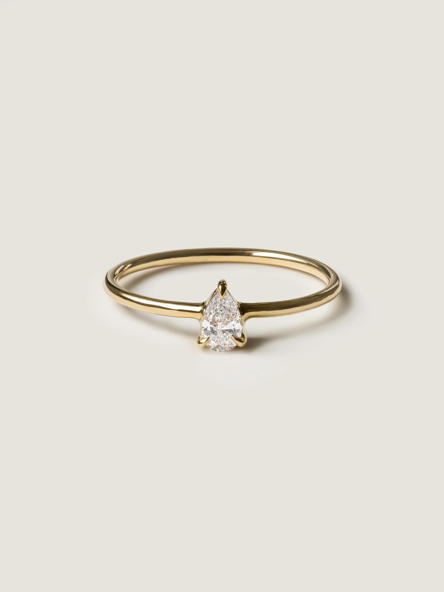 0.20 carat pear cut lab grown diamond solitaire engagement ring in prong setting with polished gold band