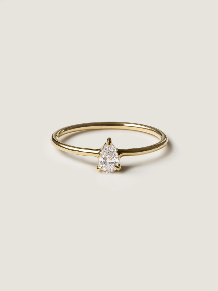 0.20 carat pear cut lab grown diamond solitaire engagement ring in prong setting with polished gold band