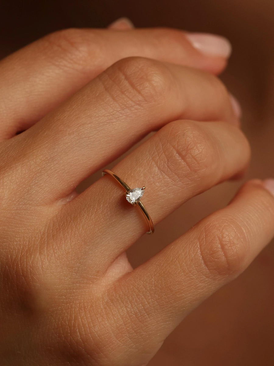 0.20 carat pear cut lab grown diamond solitaire engagement ring in prong setting with polished gold band