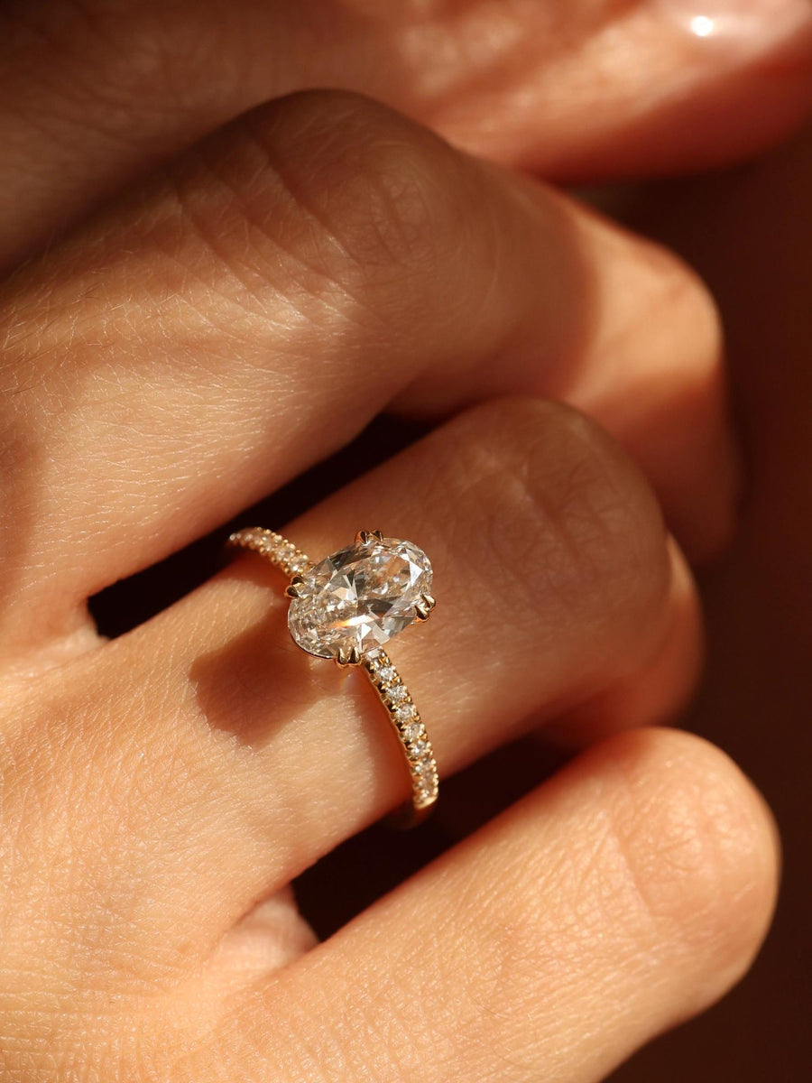 Oval cut lab grown diamond pavé engagement ring, 1.20 to 3.20 carats, with side stones set in a polished gold band
