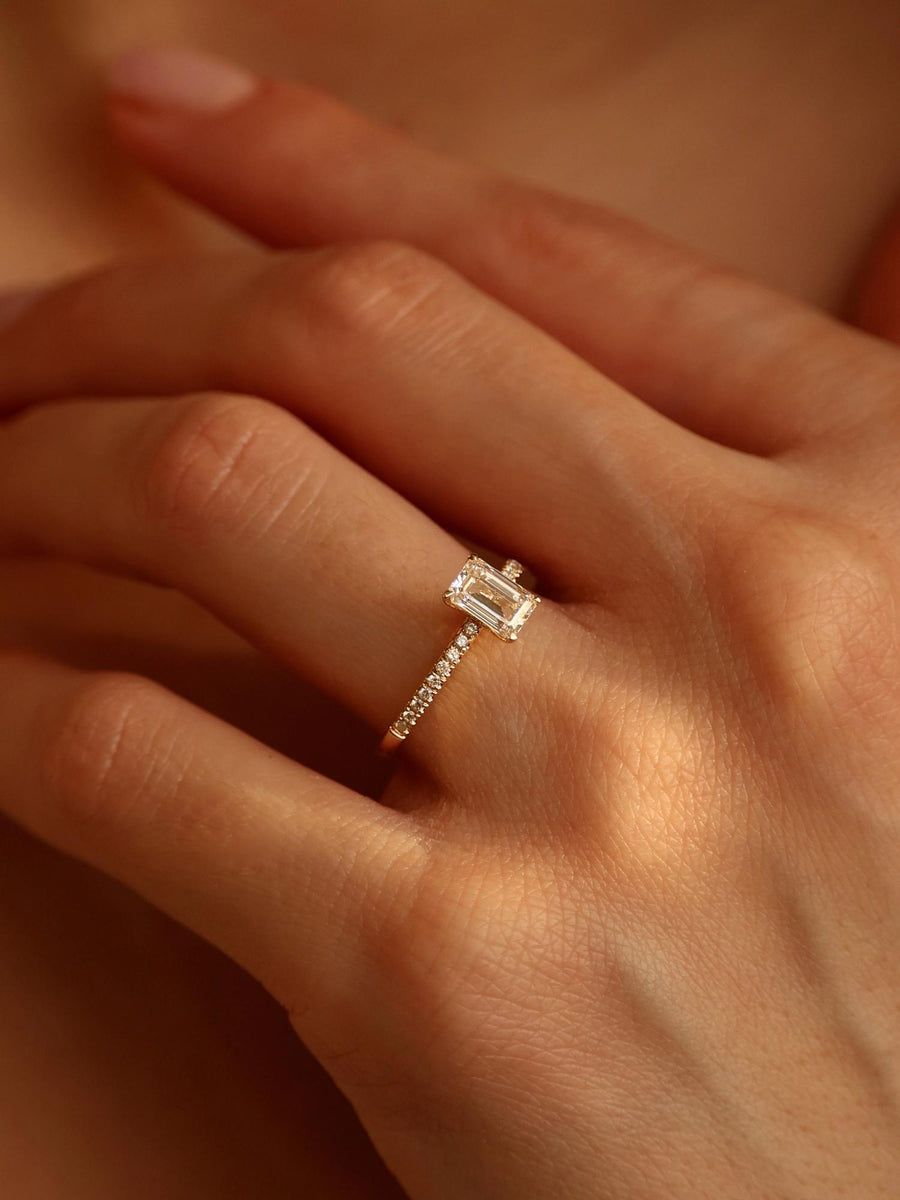 Emerald cut lab grown diamond pavé engagement ring, 0.90 to 2.50 carats, with side stones in a sleek prong setting on gold band