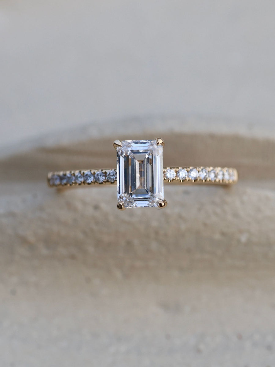 Emerald cut lab grown diamond pavé engagement ring, 0.90 to 2.50 carats, with side stones in a sleek prong setting on gold band