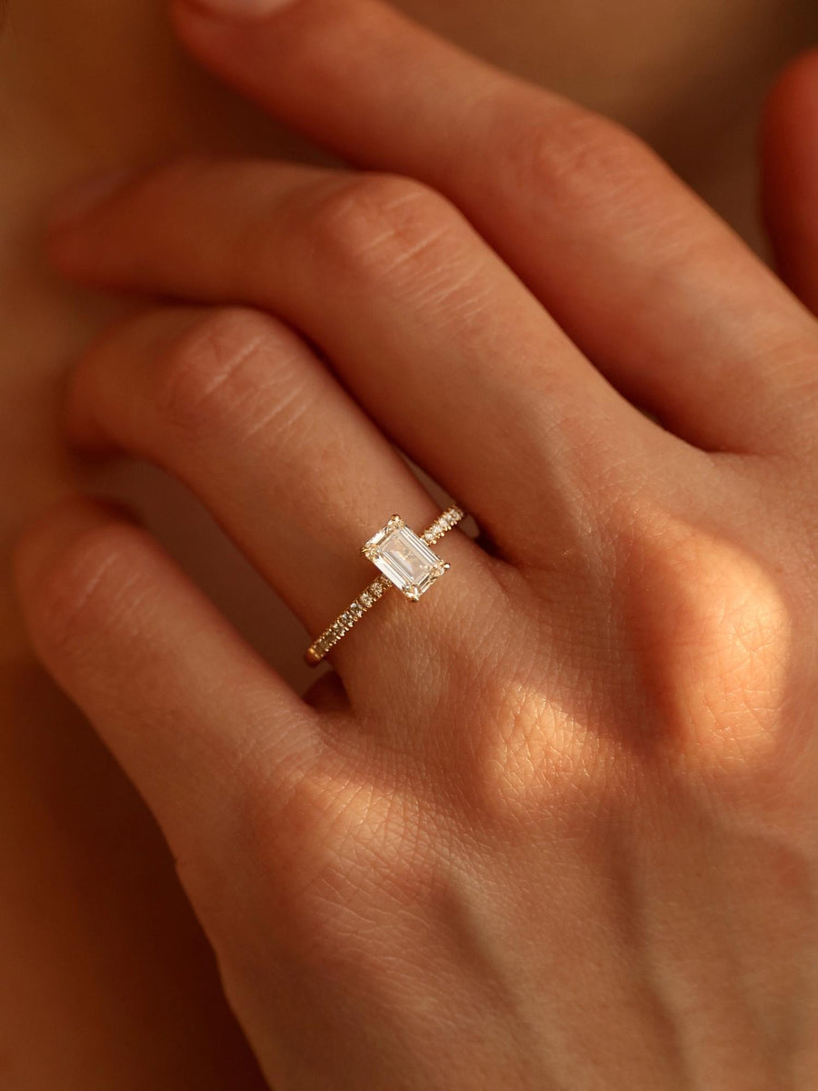 Emerald cut lab grown diamond pavé engagement ring, 0.90 to 2.50 carats, with side stones in a sleek prong setting on gold band