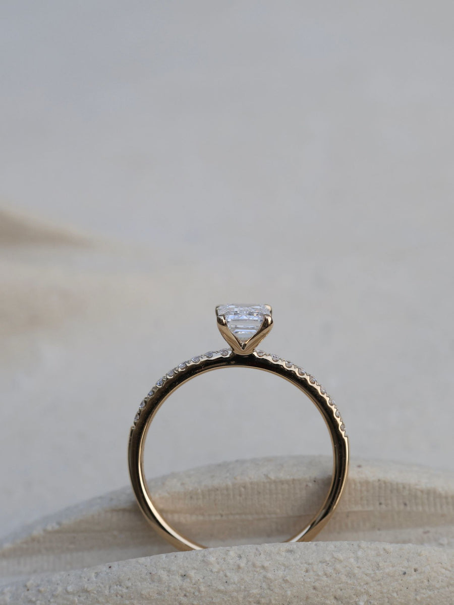 Emerald cut lab grown diamond pavé engagement ring, 0.90 to 2.50 carats, with side stones in a sleek prong setting on gold band
