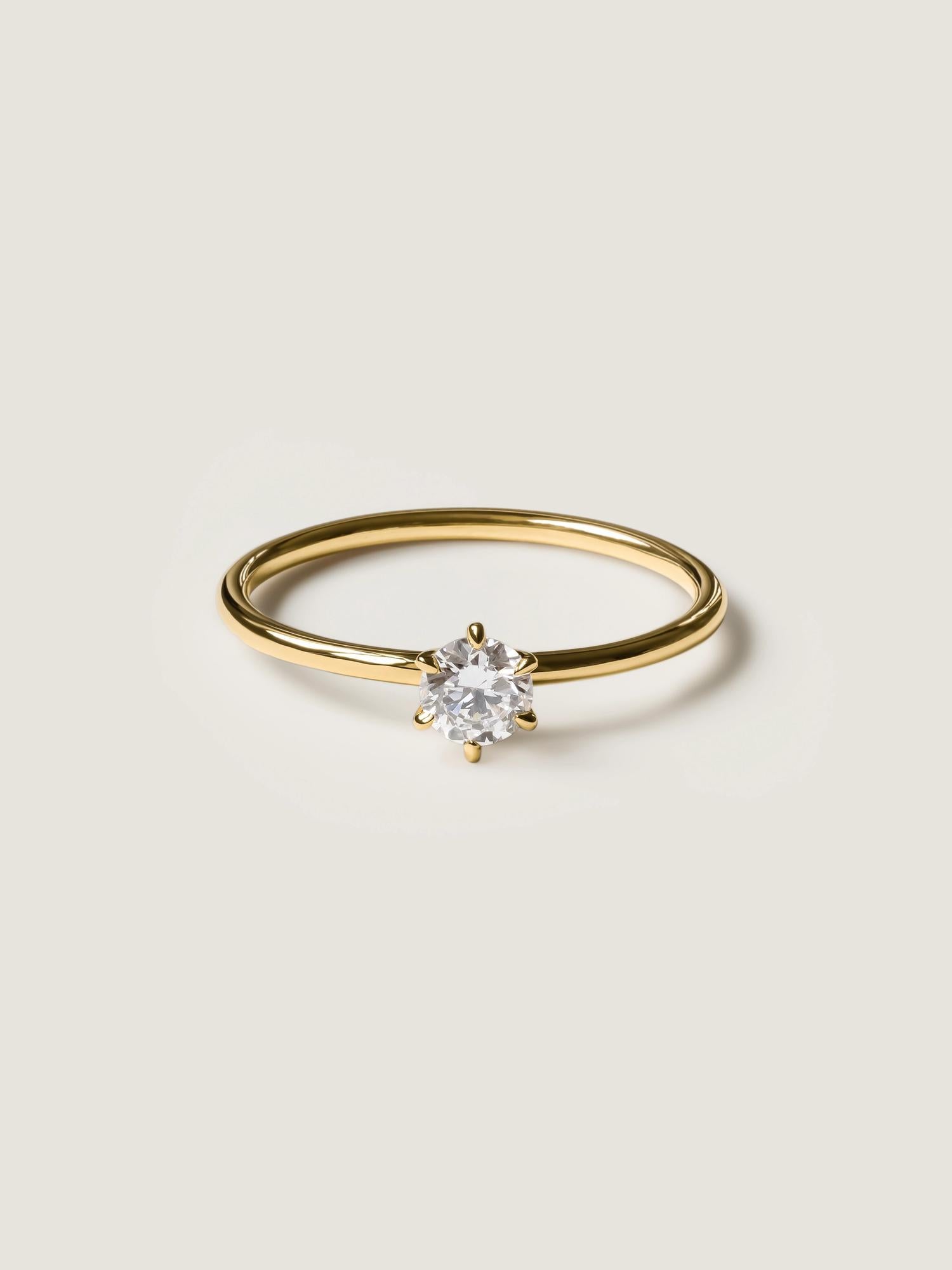 0.30 carat round cut lab grown diamond solitaire engagement ring in E/VS1 clarity, set in a sleek prong on gold band

