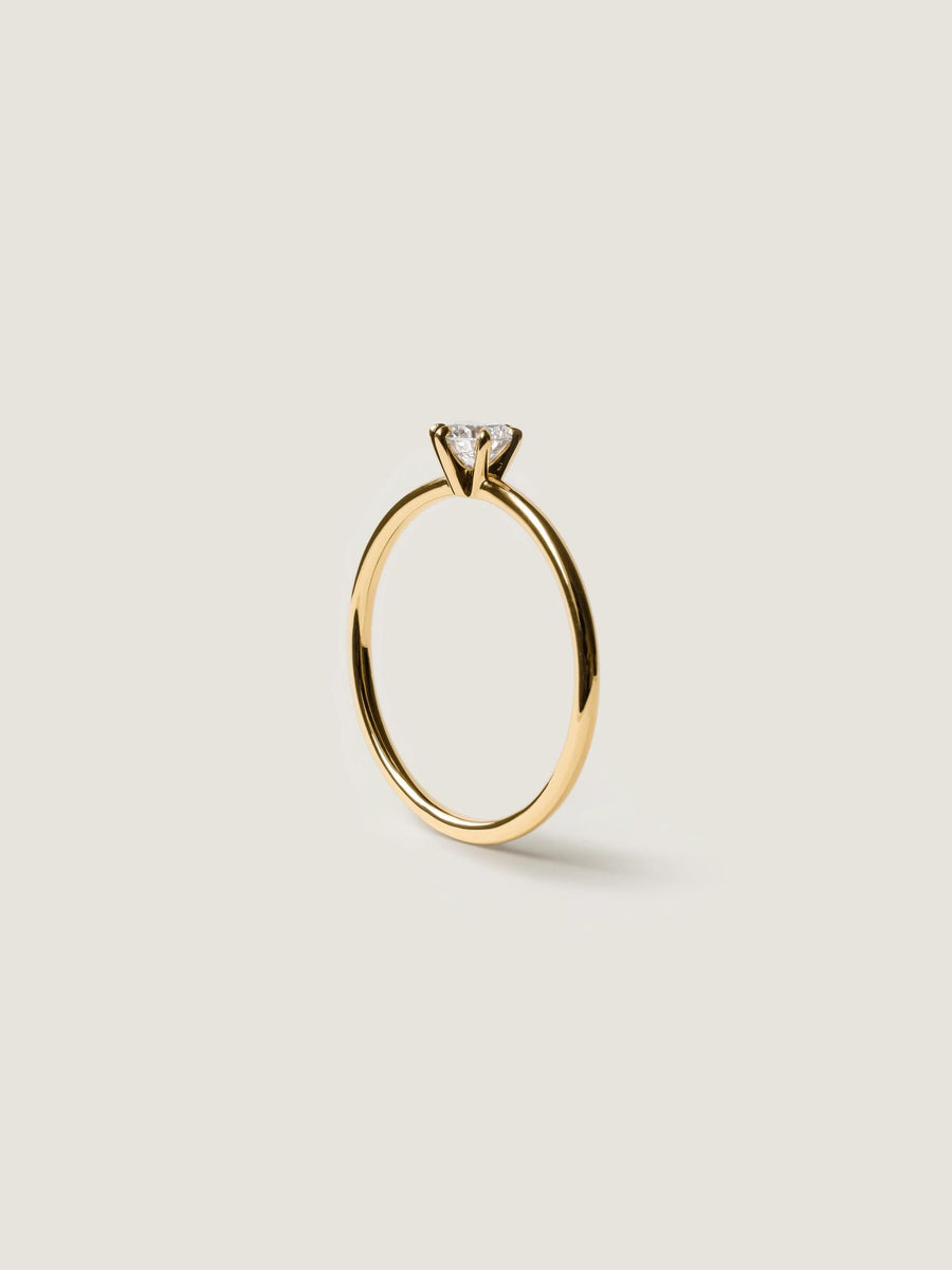 0.30 carat round cut lab grown diamond solitaire engagement ring in E/VS1 clarity, set in a sleek prong on gold band
