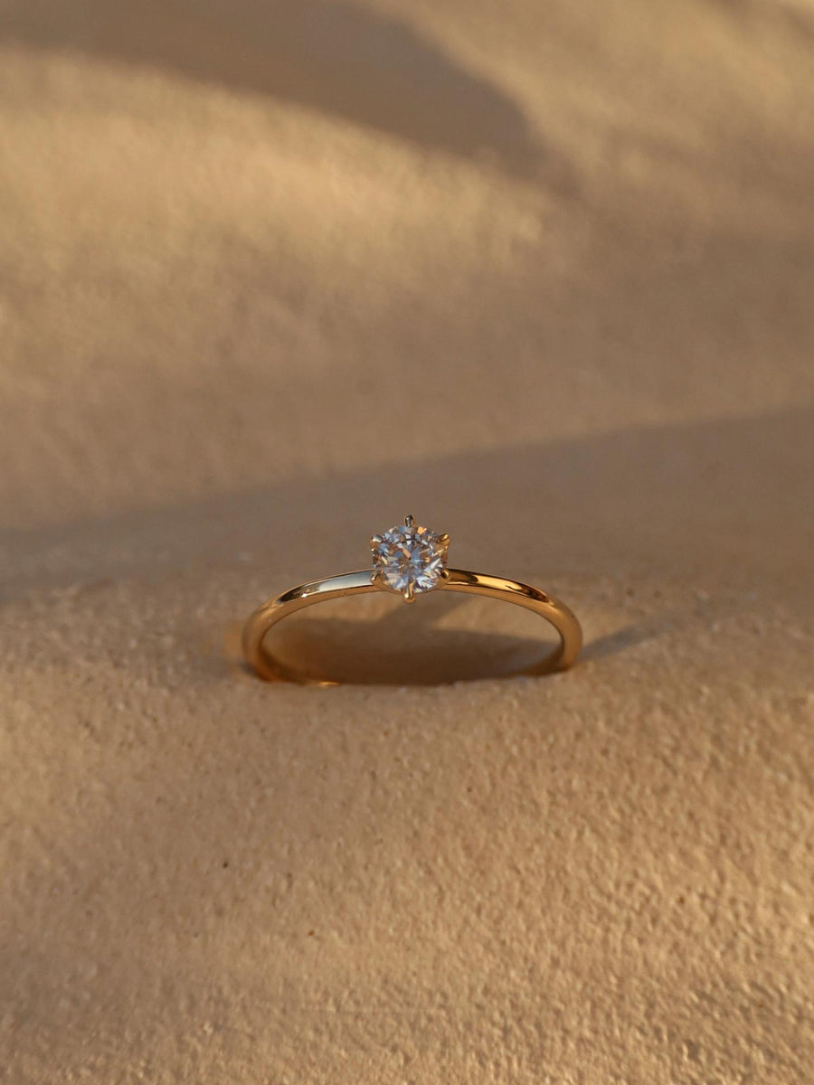 0.30 carat round cut lab grown diamond solitaire engagement ring in E/VS1 clarity, set in a sleek prong on gold band
