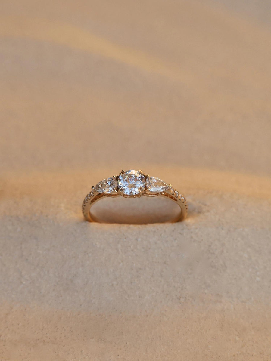 Round cut lab grown diamond three stone engagement ring, 0.50 to 2.50 carats, set in classic prong design on polished gold band