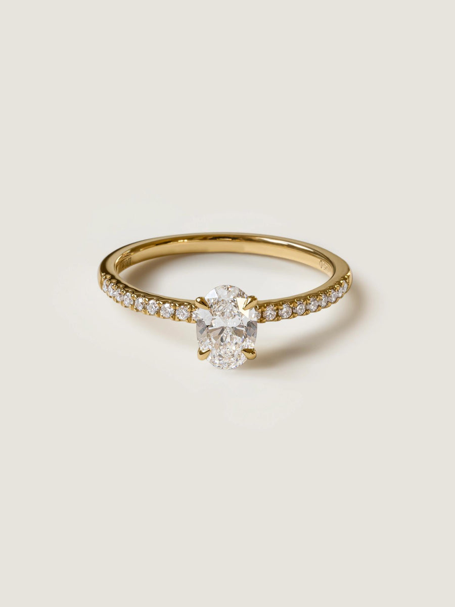 Oval cut lab grown diamond pavé engagement ring, 0.50 to 1.50 carats, with side stones in elegant prong setting on gold band