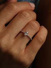 Oval cut lab grown diamond pavé engagement ring, 0.50 to 1.50 carats, with side stones in elegant prong setting on gold band