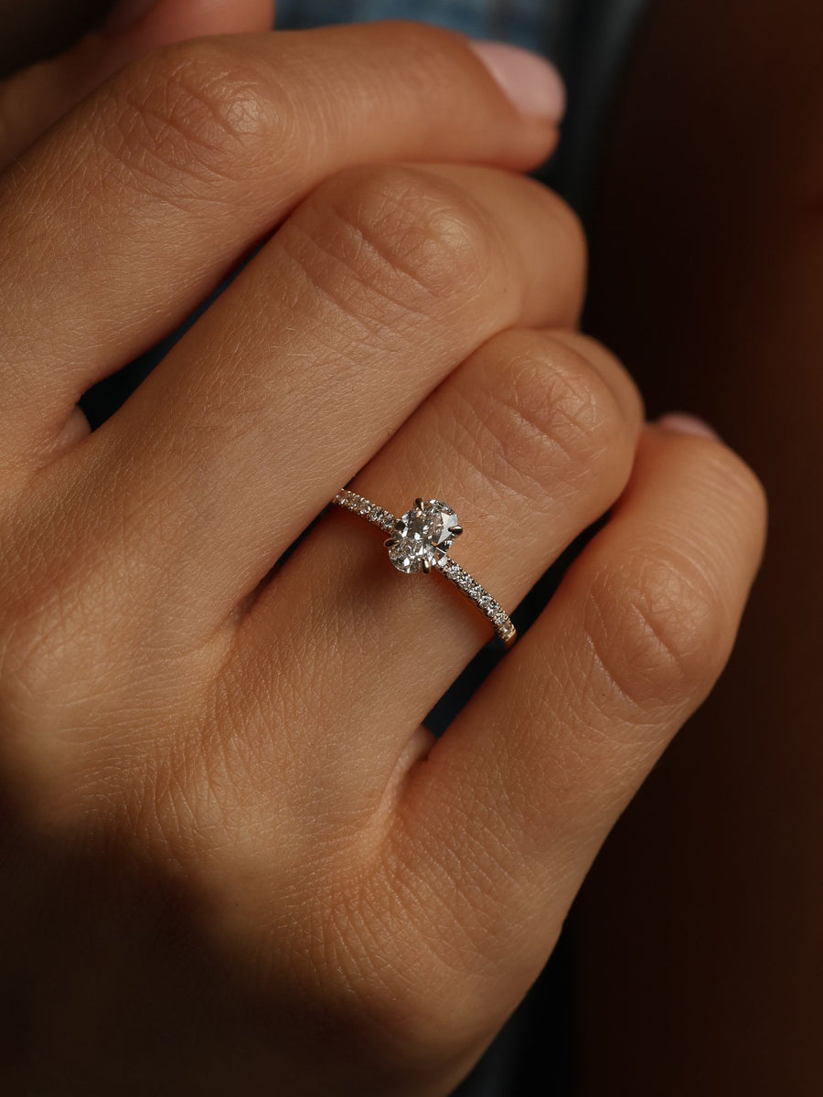 Oval cut lab grown diamond pavé engagement ring, 0.50 to 1.50 carats, with side stones in elegant prong setting on gold band