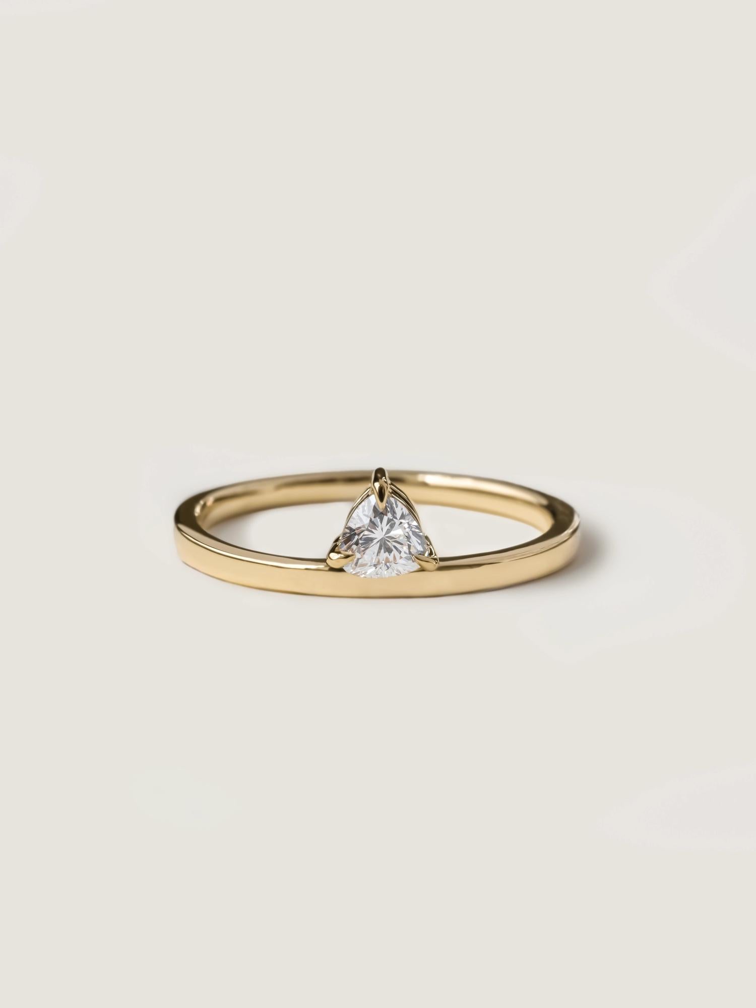 0.20 carat trillion cut lab grown diamond solitaire engagement ring in classic prong setting on polished gold band