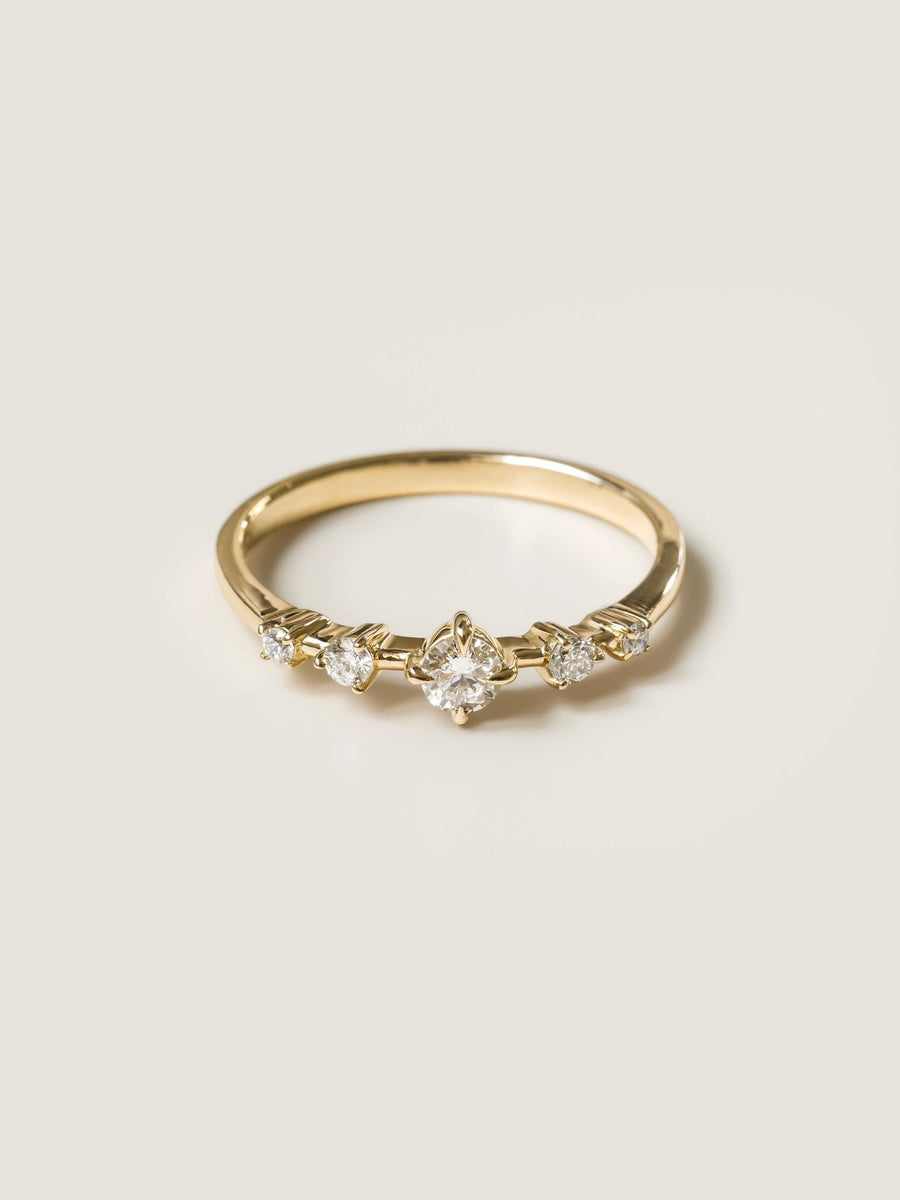 0.11 carat round cut lab grown diamond dainty engagement ring in E/VS1 clarity, set in a slim gold band with prong setting