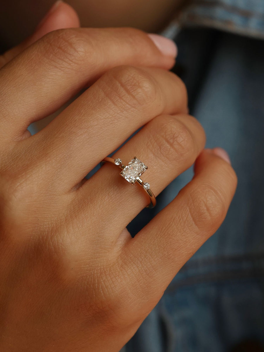 Radiant cut lab grown diamond three stone engagement ring, 1.05 to 3.05 carats, set in polished gold band with prong setting