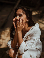 0.11 carat round cut lab grown diamond dainty engagement ring in a slim prong setting on polished gold band