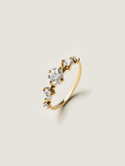 0.11 carat round cut lab grown diamond dainty engagement ring in a slim prong setting on polished gold band