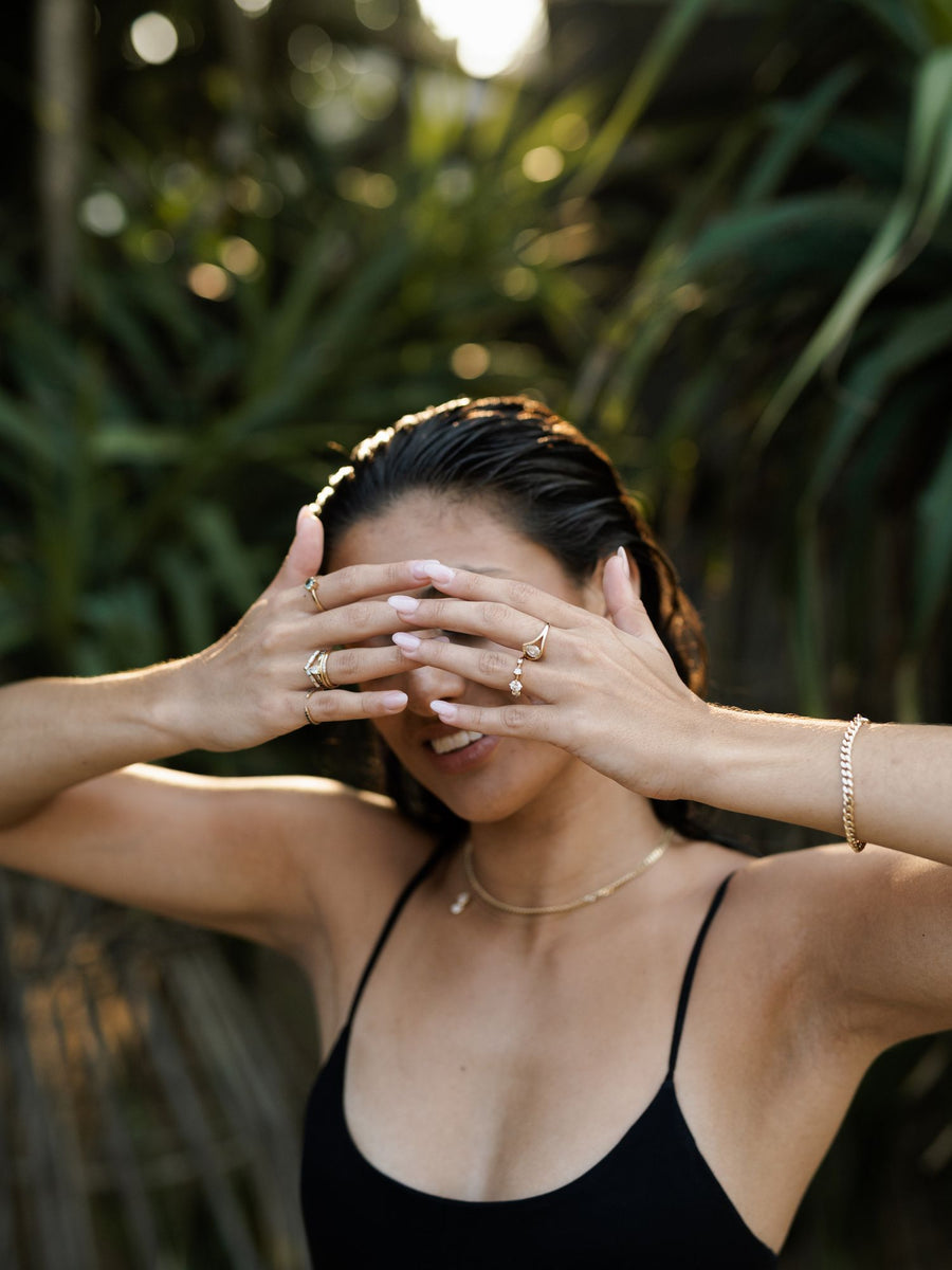 0.11 carat round cut lab grown diamond dainty engagement ring in a slim prong setting on polished gold band