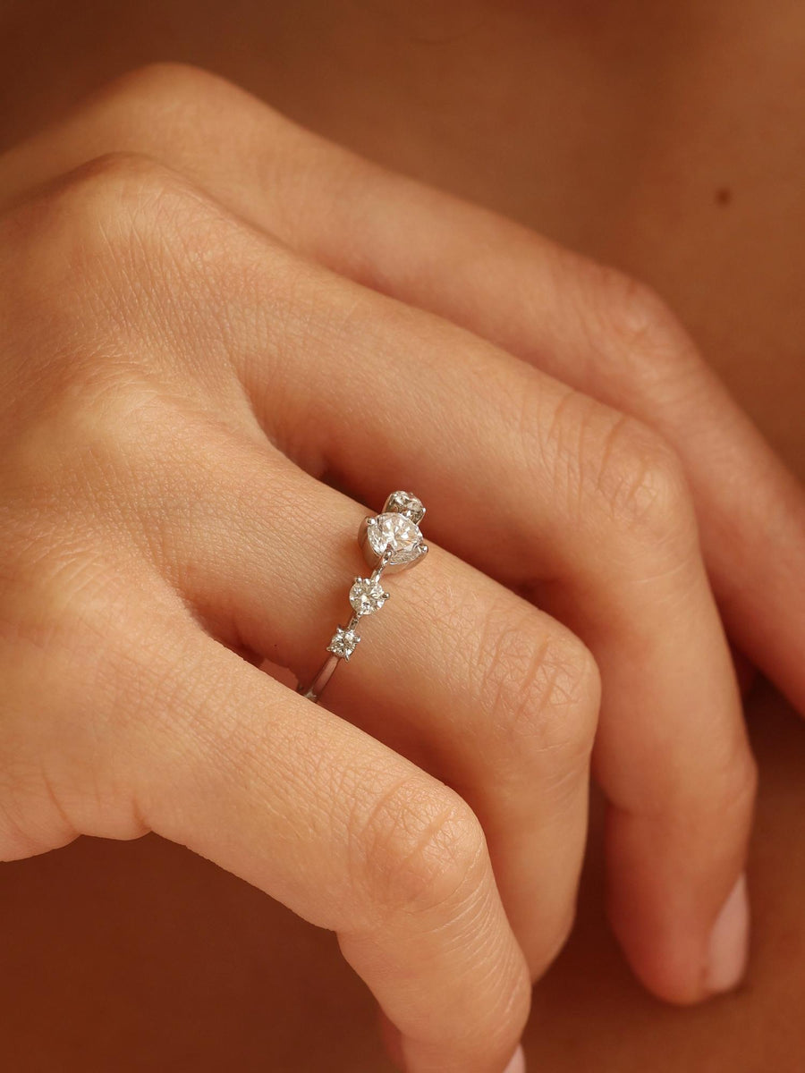 0.11 carat round cut lab grown diamond dainty engagement ring in a slim prong setting on polished gold band