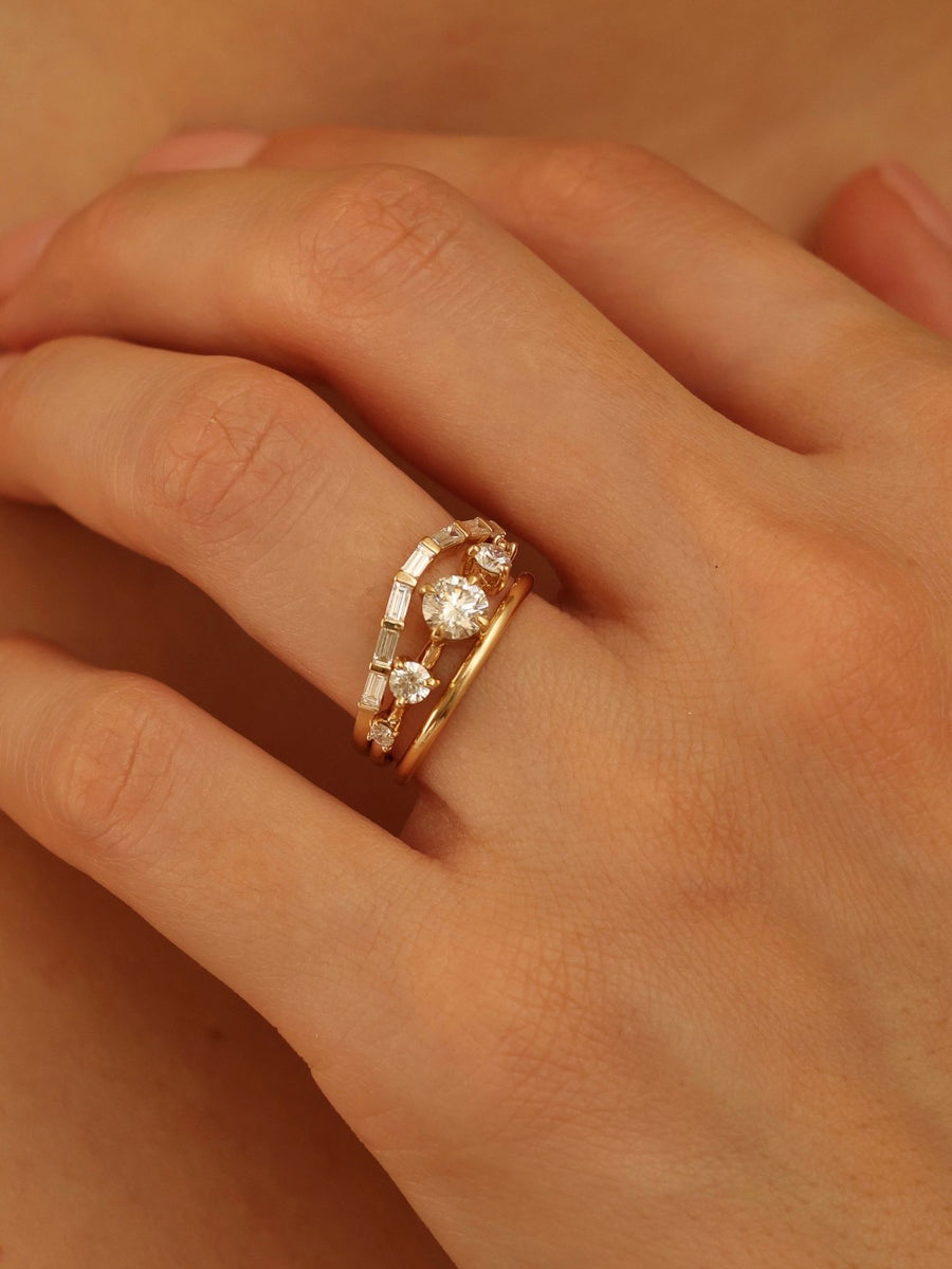0.11 carat round cut lab grown diamond dainty engagement ring in a slim prong setting on polished gold band
