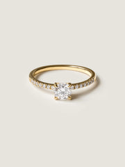 Round cut E/VS1 lab grown diamond pavé engagement ring, 0.50 to 2.50 carats, with side stones set in polished gold band

