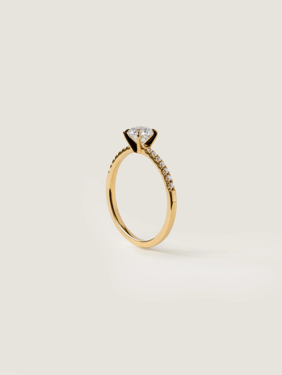 Round cut E/VS1 lab grown diamond pavé engagement ring, 0.50 to 2.50 carats, with side stones set in polished gold band

