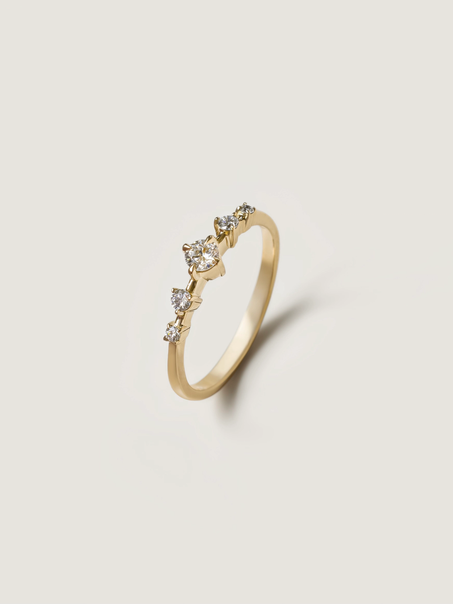 0.11 carat round cut lab grown diamond dainty engagement ring in E/VS1 clarity, set in a slim gold band with prong setting


