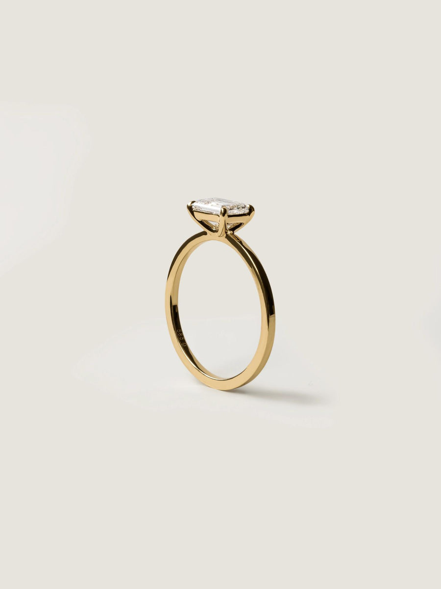 East-west emerald cut lab grown diamond solitaire engagement ring, 1.0 to 3.0 carats, set in prong design on polished gold band
