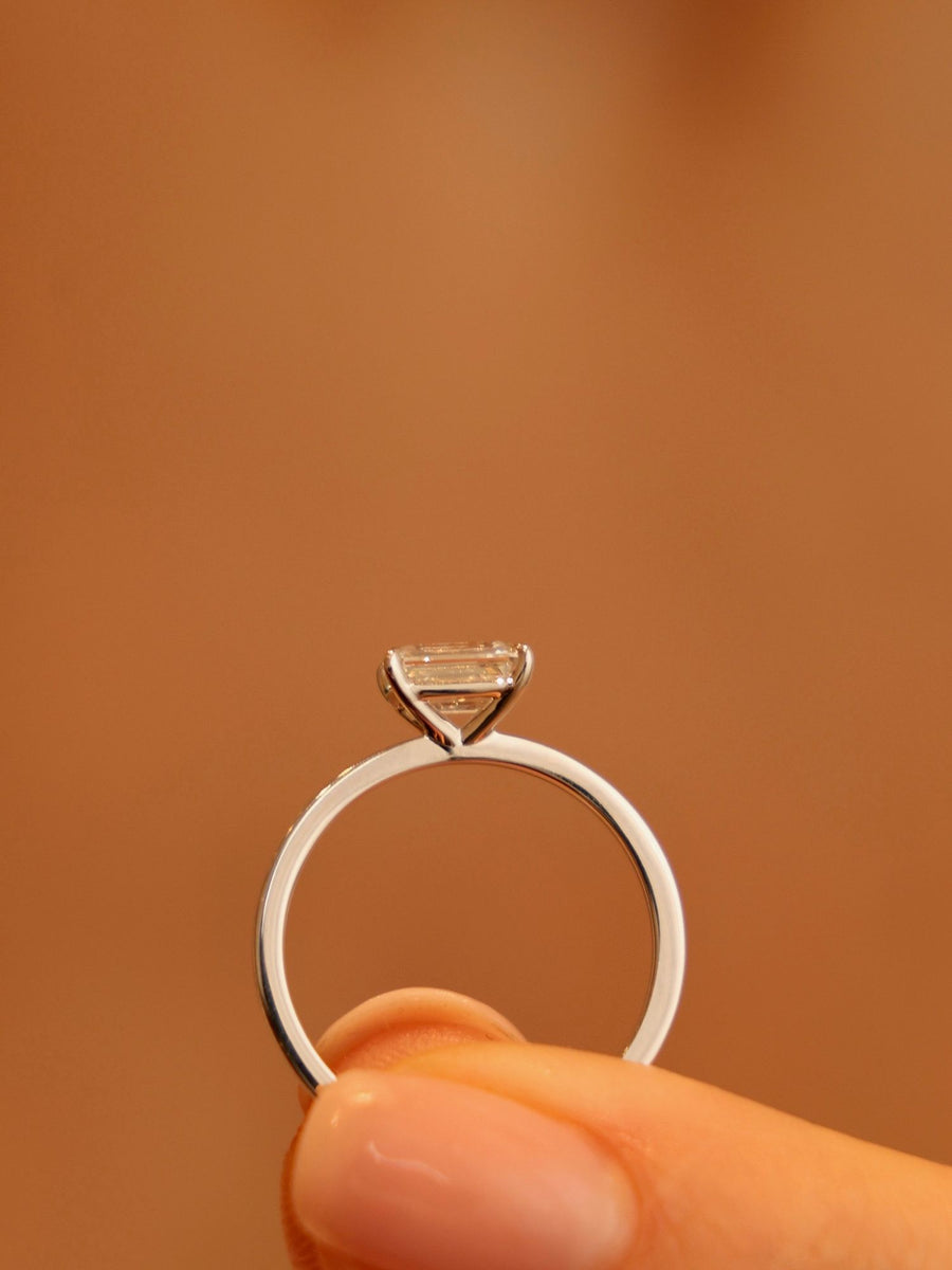 East-west emerald cut lab grown diamond solitaire engagement ring, 1.0 to 3.0 carats, set in prong design on polished gold band
