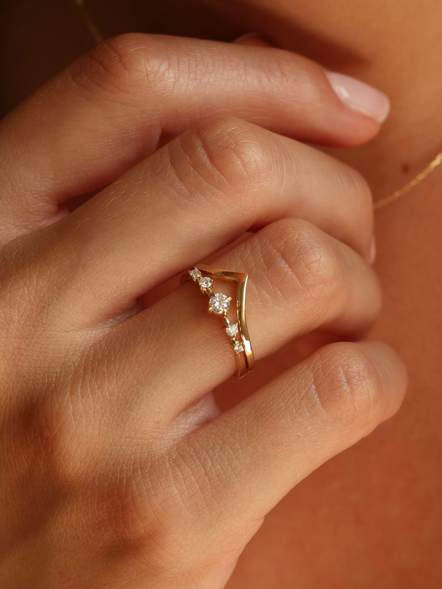 0.11 carat round cut lab grown diamond dainty engagement ring in E/VS1 clarity, set in a slim gold band with prong setting
