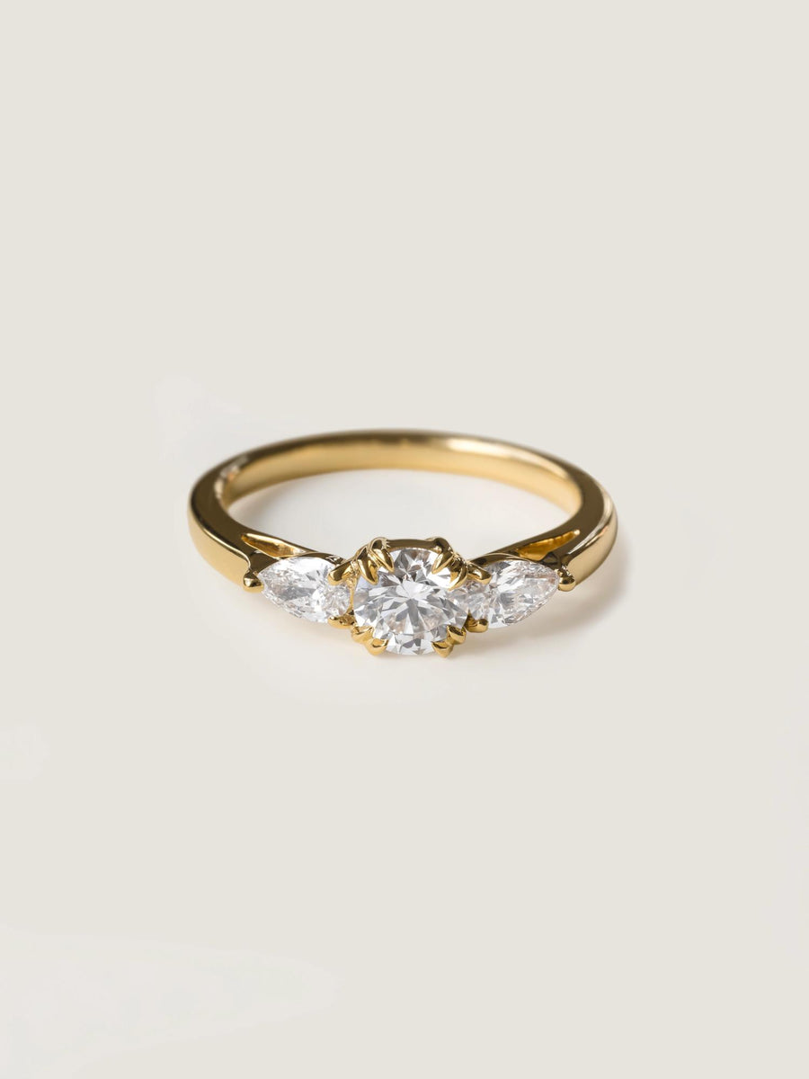 0.50 carat round cut lab grown diamond three stone engagement ring with prong setting on polished gold band