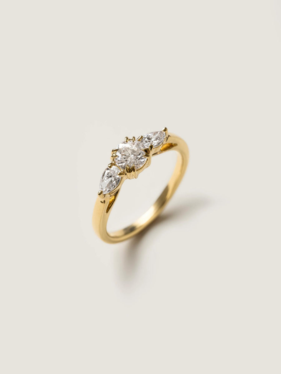 0.50 carat round cut lab grown diamond three stone engagement ring with prong setting on polished gold band