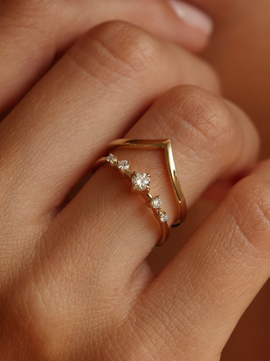 0.11 carat round cut lab grown diamond dainty engagement ring in E/VS1 clarity, set in a slim gold band with prong setting