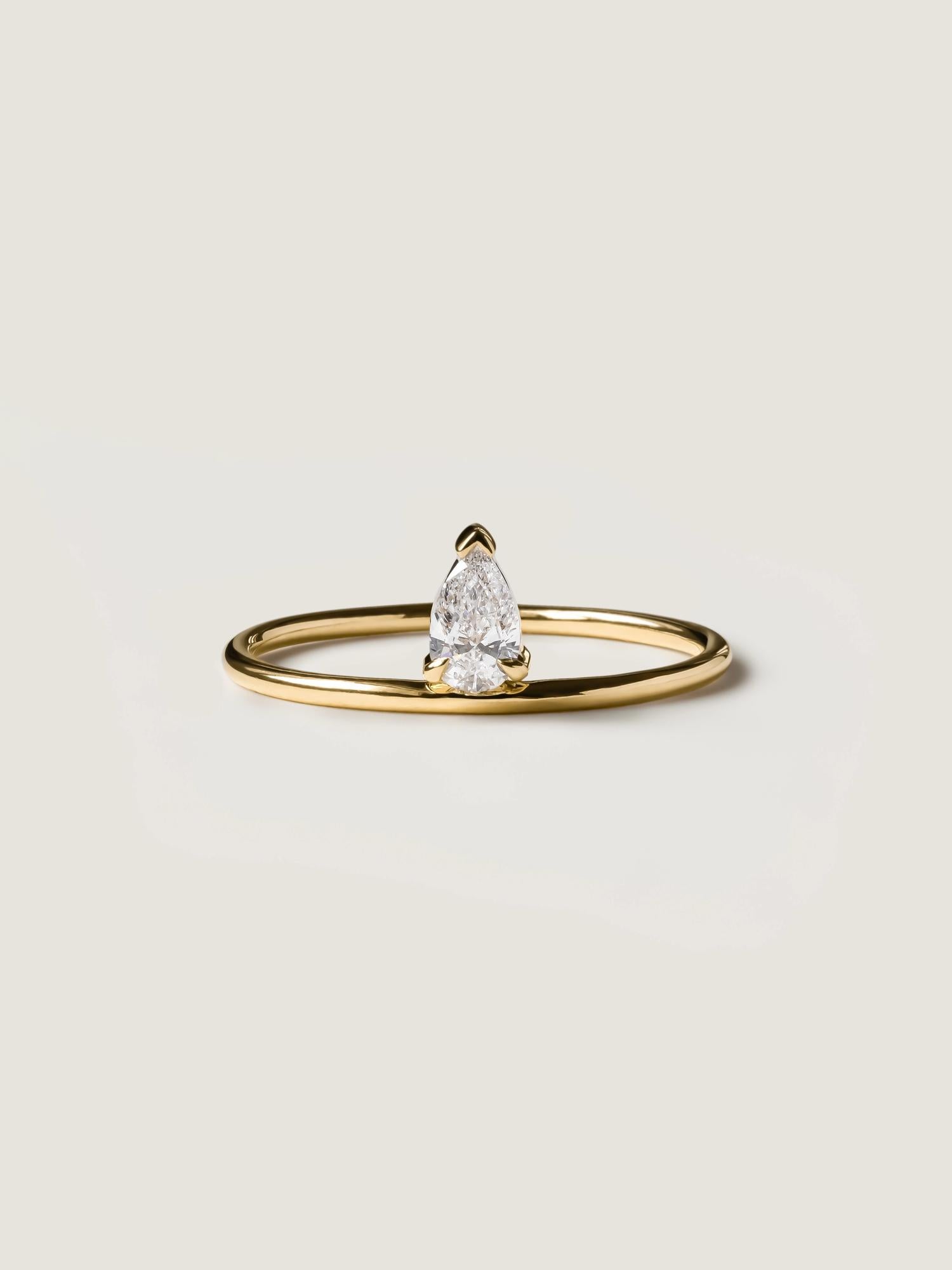 0.30 carat pear cut lab grown diamond solitaire engagement ring in prong setting on polished gold band