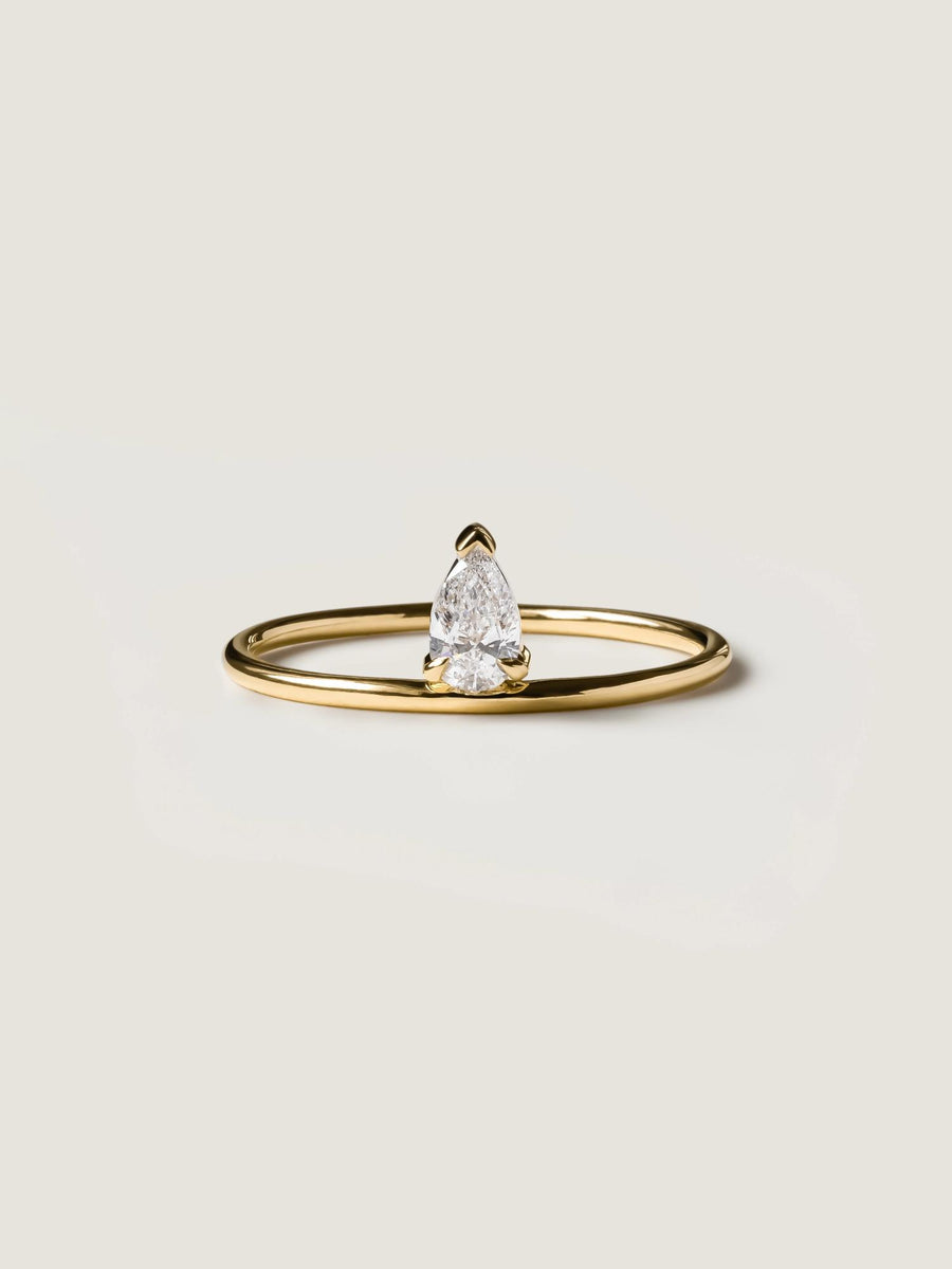 0.30 carat pear cut lab grown diamond solitaire engagement ring in prong setting on polished gold band