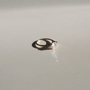 1.0 carat emerald cut lab grown diamond three stone engagement ring with side diamonds set on a polished gold band