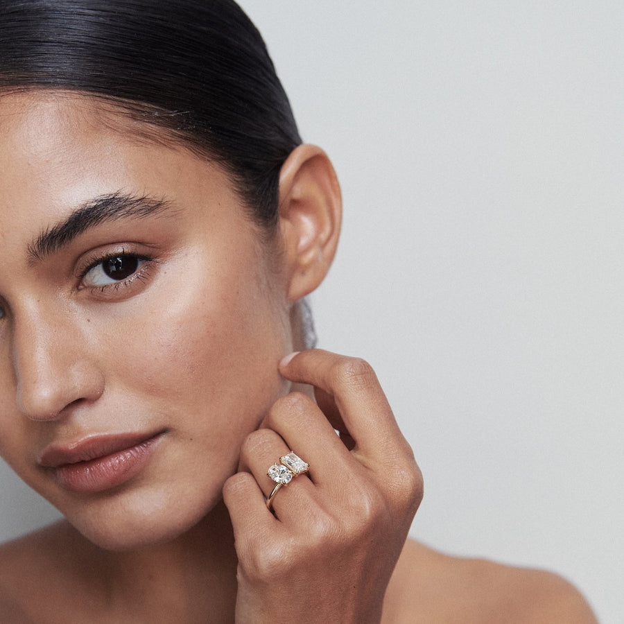 Oval and radiant cut lab grown diamond two stone engagement ring in elegant prong setting on polished gold band