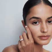 1.0 carat emerald cut lab grown diamond three stone engagement ring with side diamonds set on a polished gold band