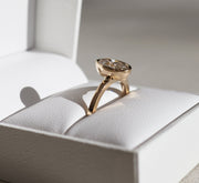 Oval cut lab grown diamond bezel engagement ring in polished gold band with secure modern setting