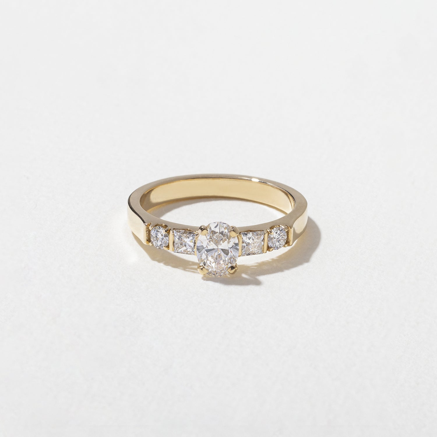 0.50 carat oval cut lab grown diamond five stone engagement ring in classic prong setting on polished gold band