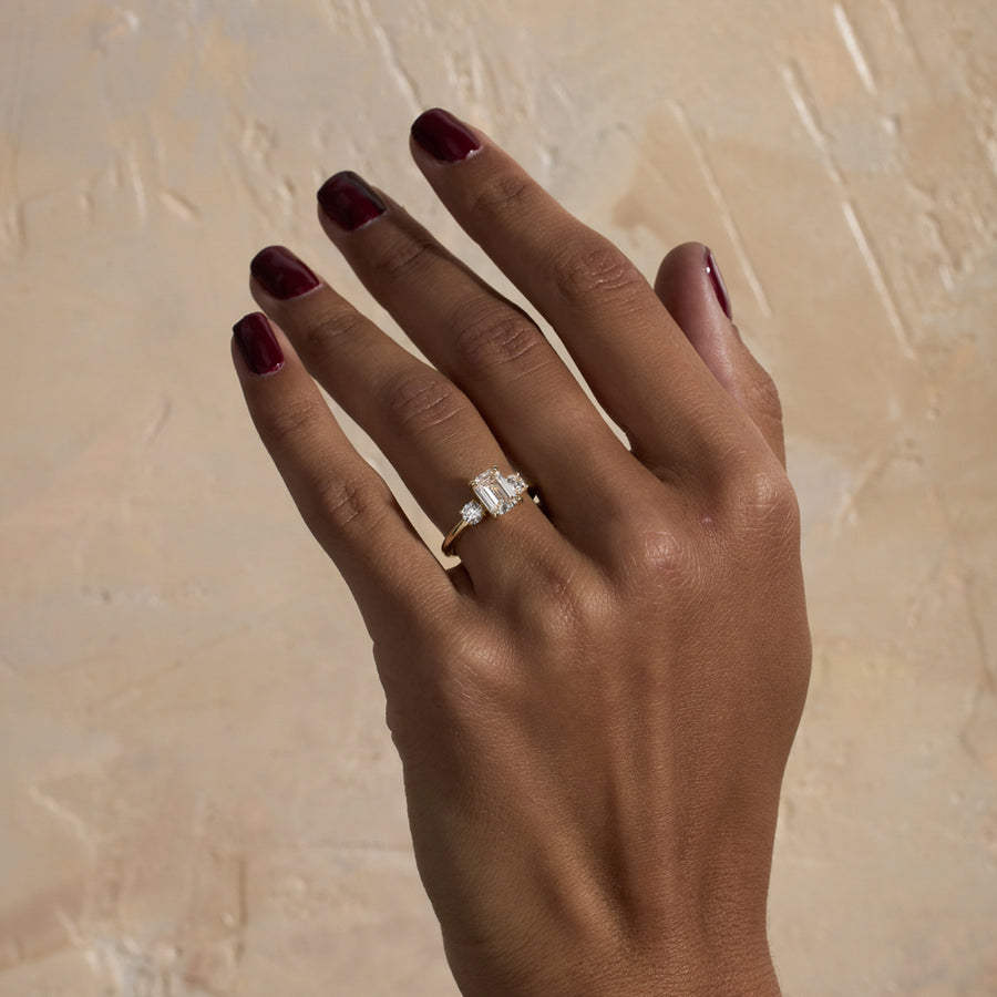 1.29 carat emerald cut lab grown diamond three stone engagement ring in G/VS1 clarity with baguette side stones and polished metal band