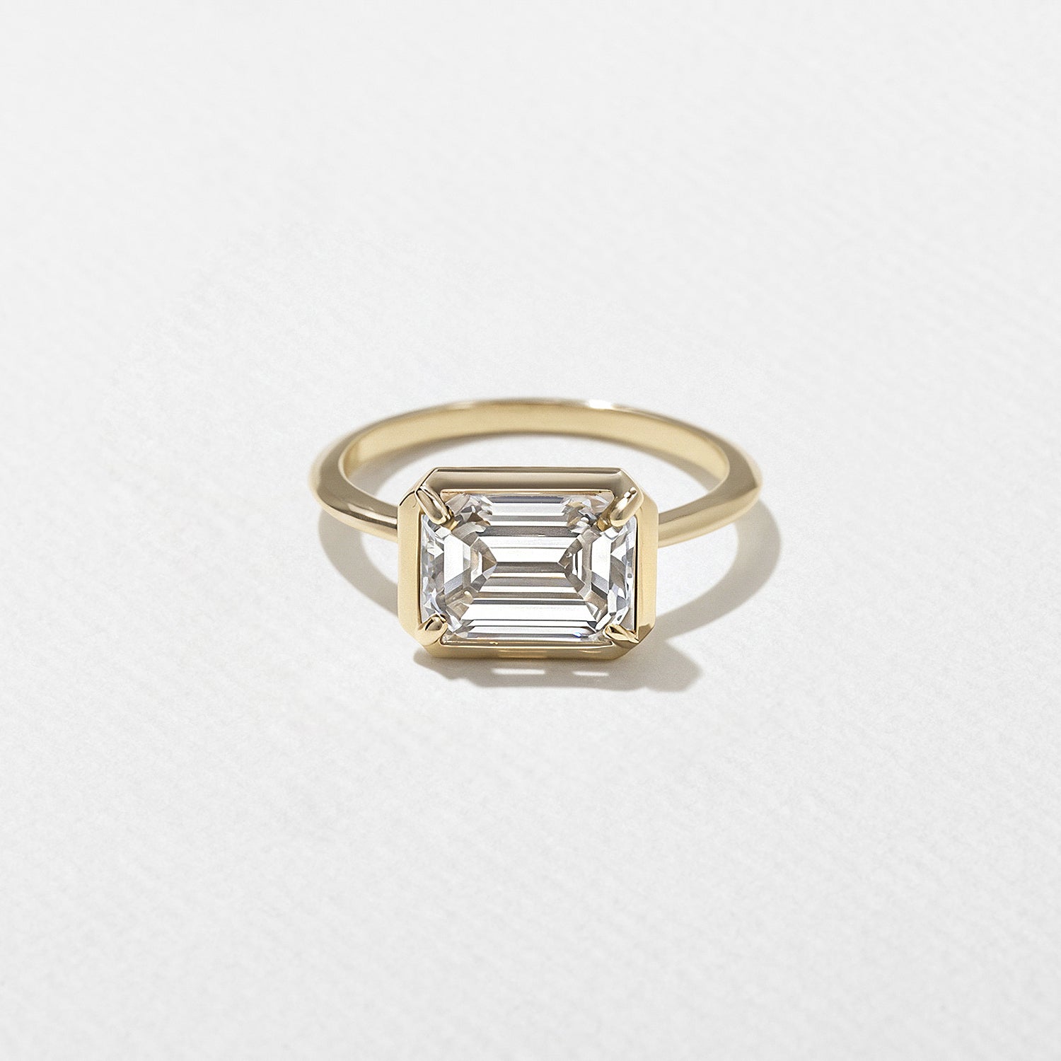 1.30 to 3.30 carat emerald cut lab grown diamond solitaire ring in G/VS1 clarity with sleek bezel setting and smooth polished band