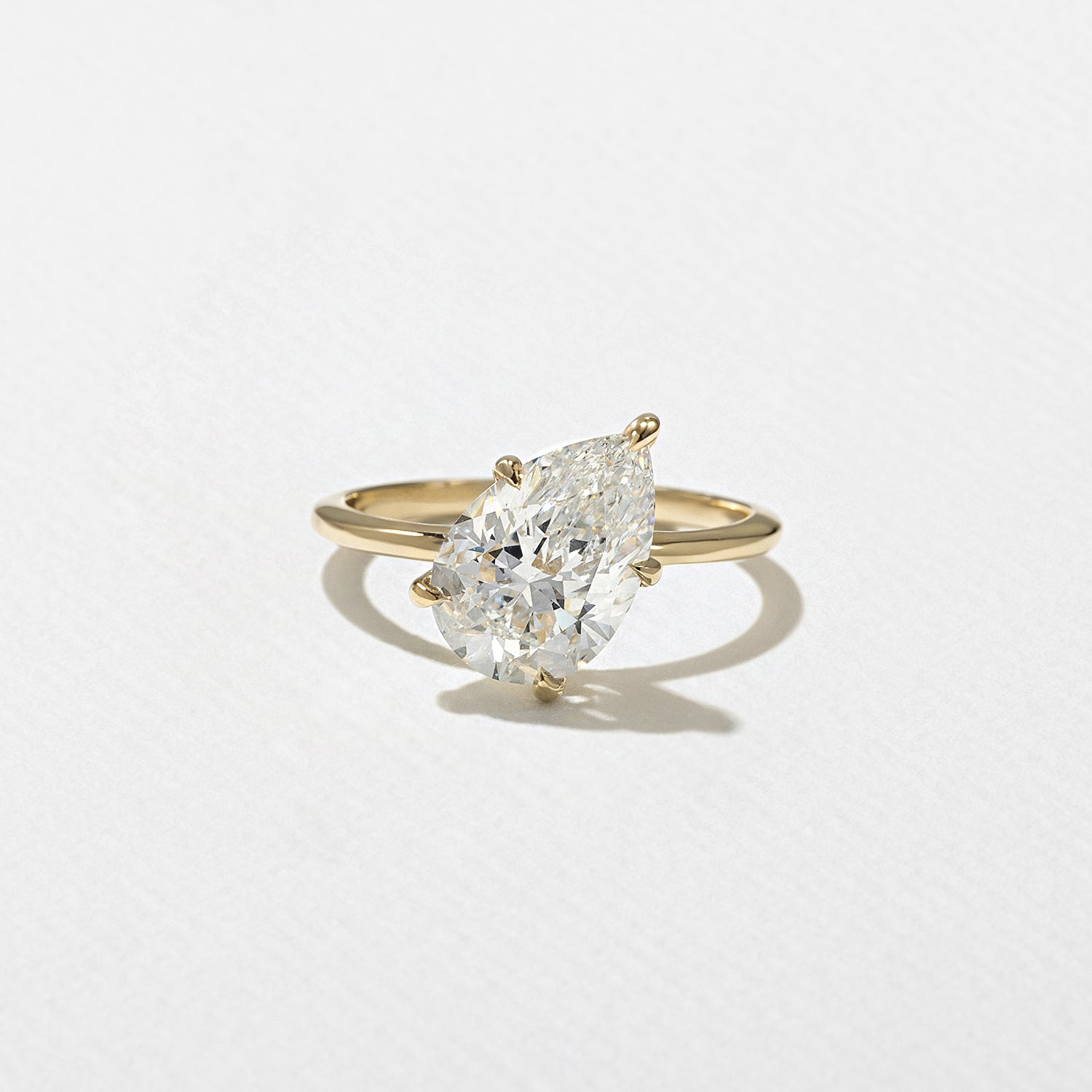 Pear cut lab grown diamond solitaire engagement ring, 2.54 to 3.54 carats, set in a classic prong setting on polished gold band