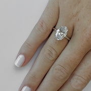 Oval cut lab grown diamond solitaire engagement ring in prong setting on polished gold band