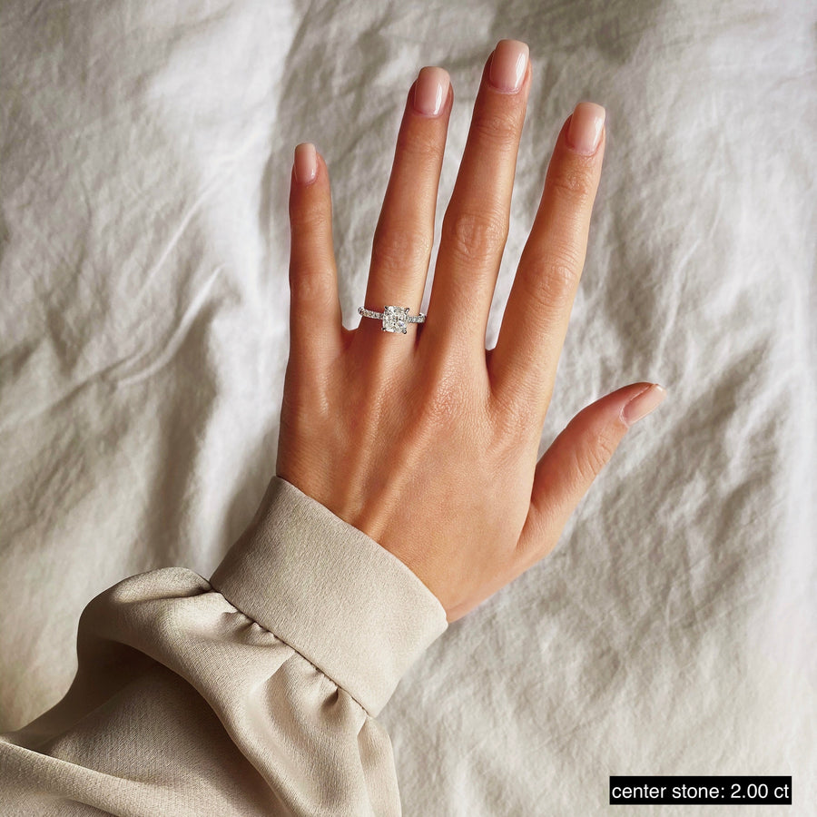 Cushion cut lab grown diamond engagement ring with pavé side stones set in polished gold band, showcasing brilliance and elegance