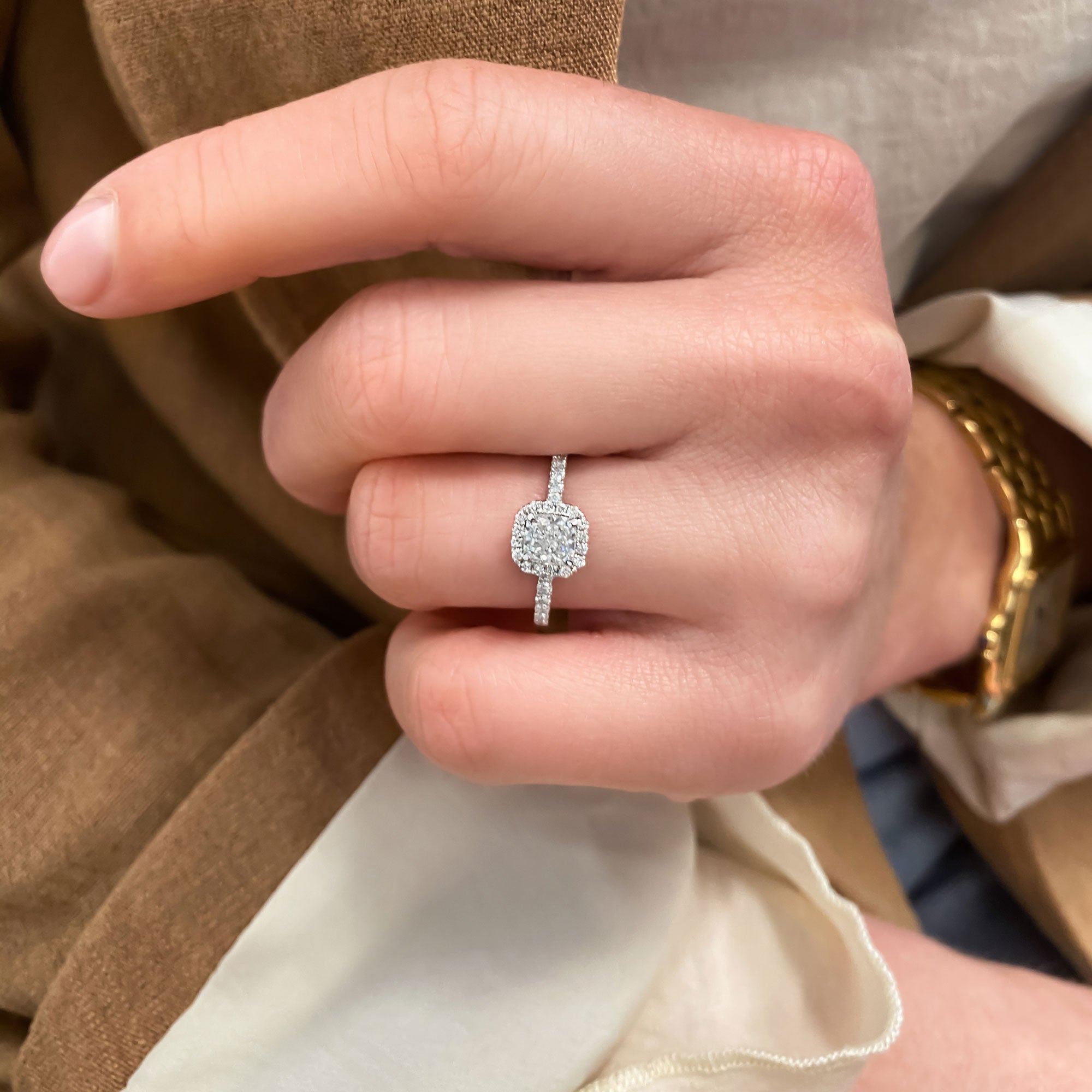 Cushion cut lab grown diamond engagement ring with halo and pavé setting on a polished gold band