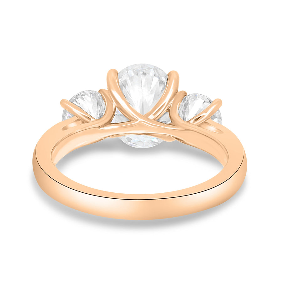 Oval cut lab grown diamond three stone engagement ring with center stone and side diamonds in classic prong setting on gold band