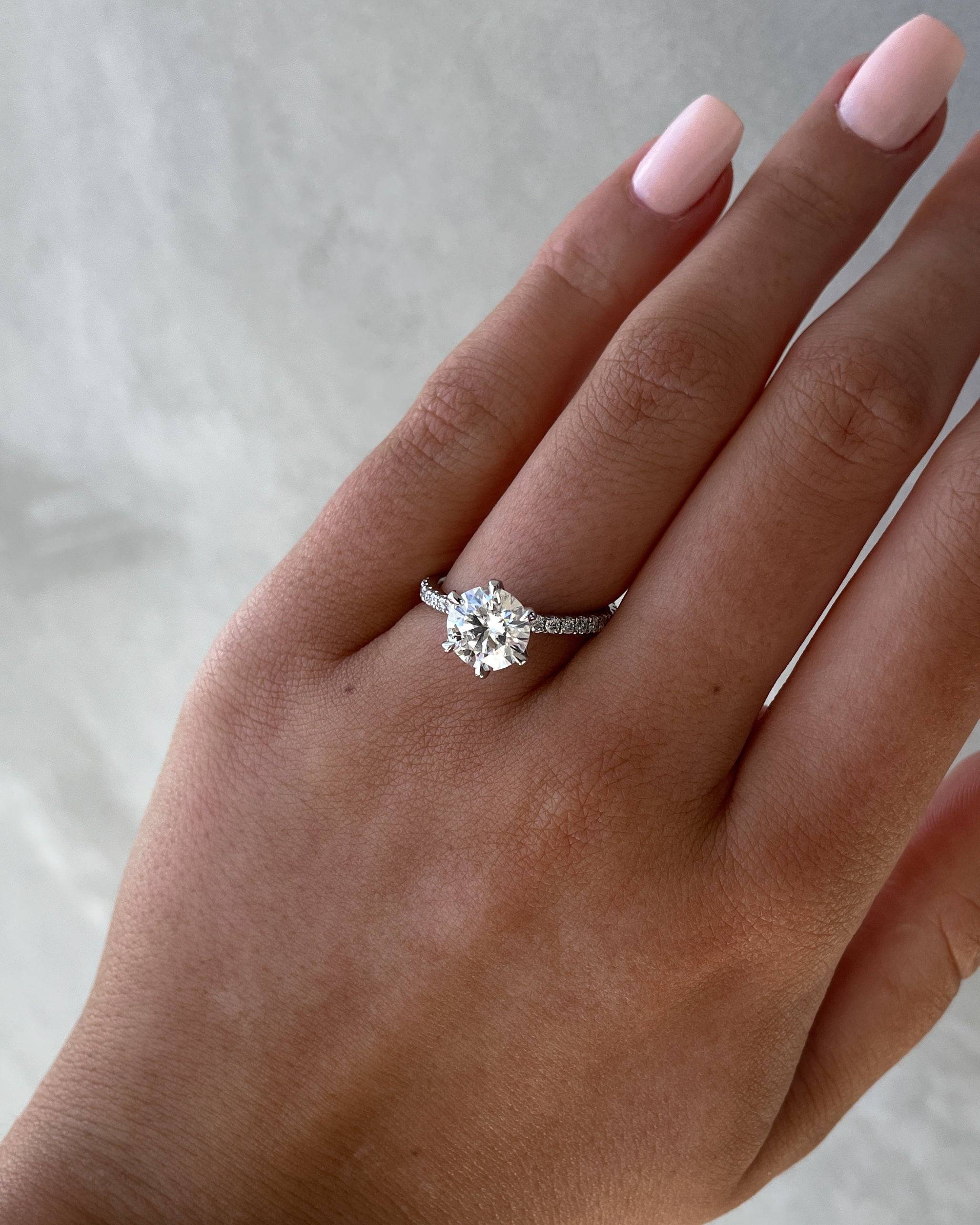 Round cut lab grown diamond engagement ring with pavé setting on polished gold band
