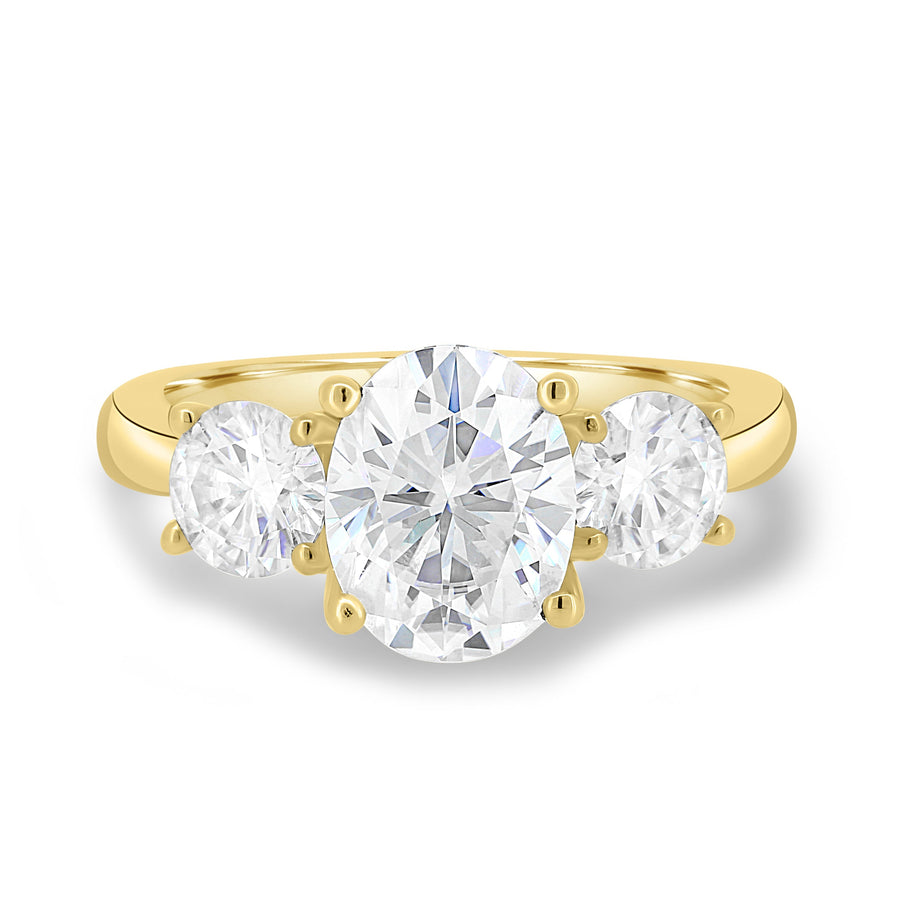 Oval cut lab grown diamond three stone engagement ring with center stone and side diamonds in classic prong setting on gold band