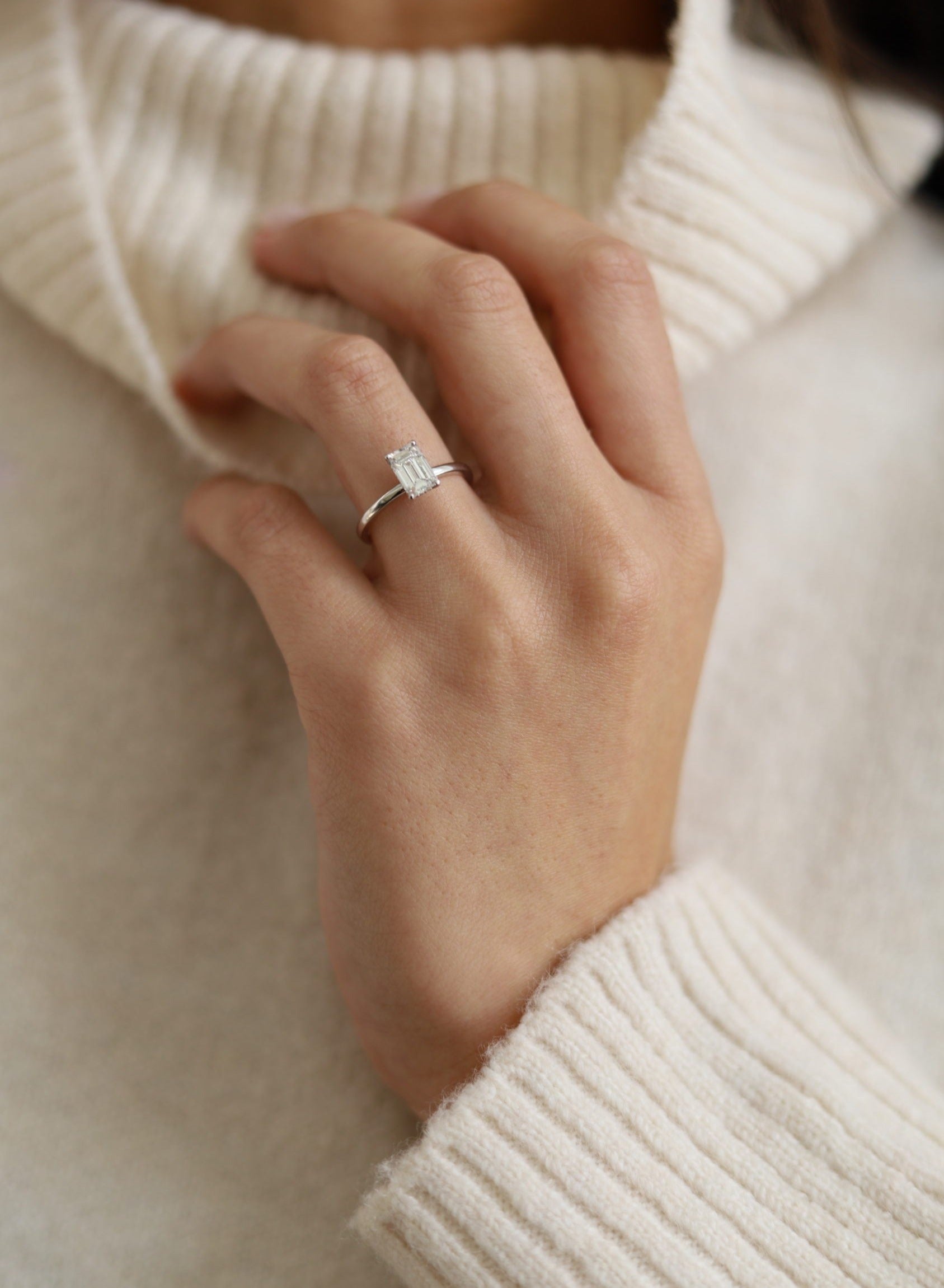 Emerald cut lab grown diamond engagement ring with hidden halo setting in prong design on polished gold band