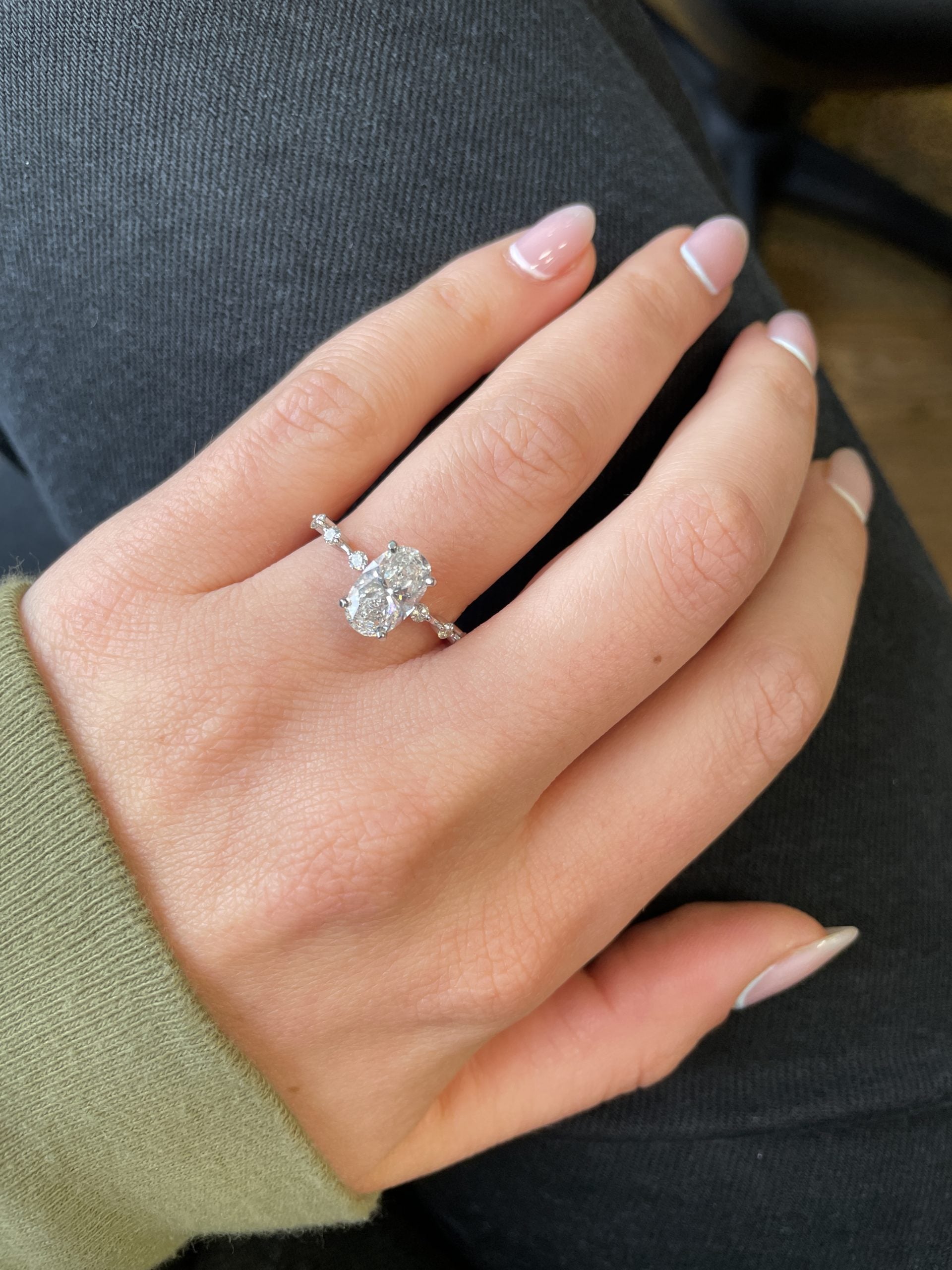 Oval cut lab grown diamond engagement ring with dainty prong setting on slim gold band, designed for delicate and elegant style